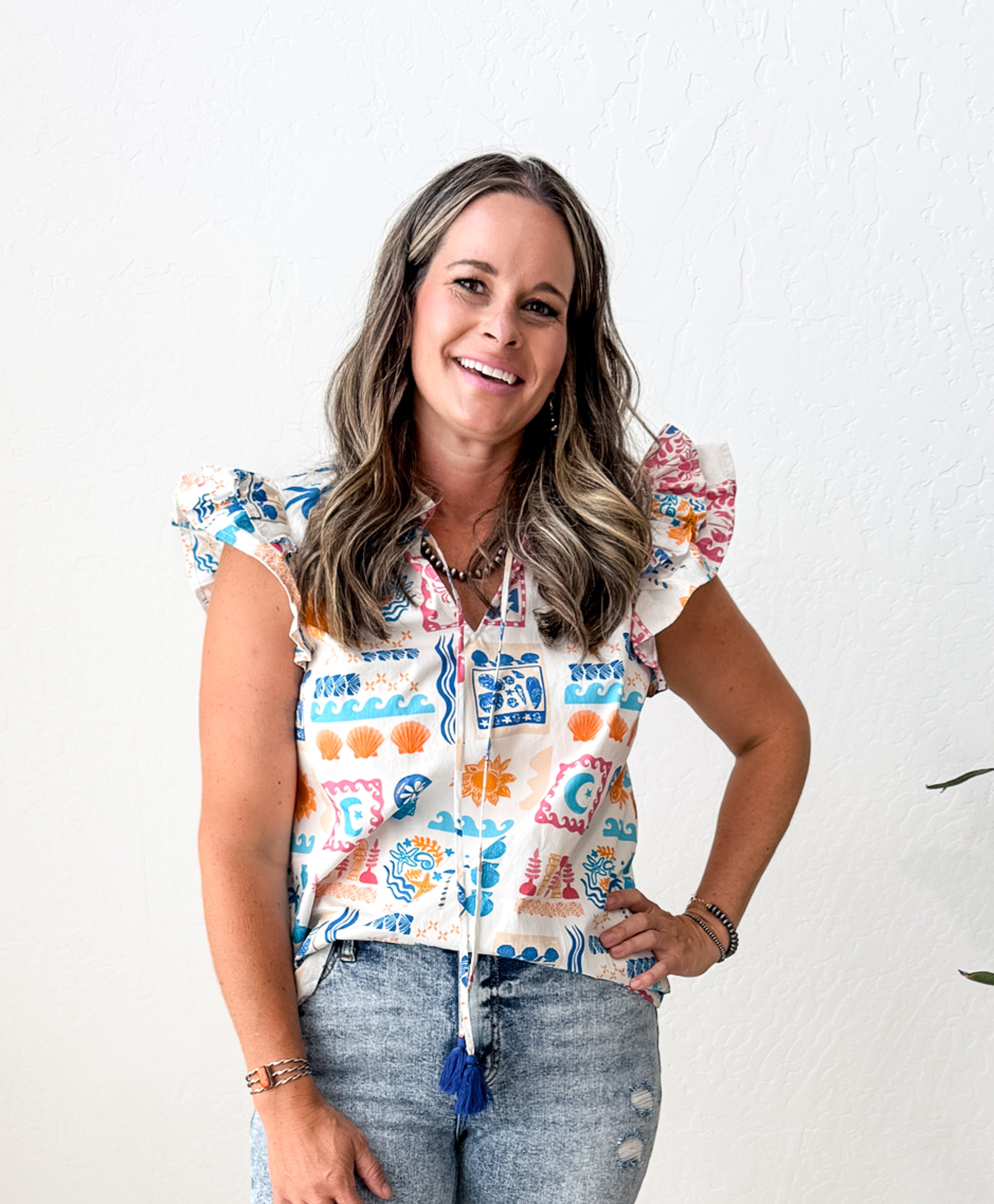 Woman wearing a colorful patterned top with a white background